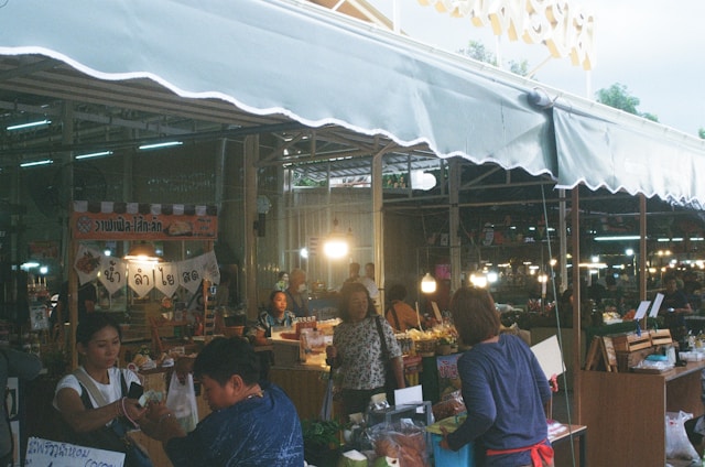 A vibrant marketplace scene with diverse products from Thailand and China displayed on shelves.