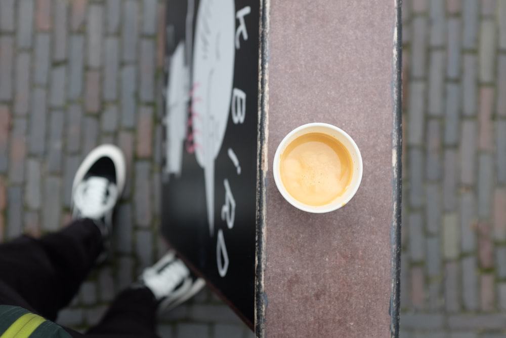 a cup of coffee sitting on top of a sign
