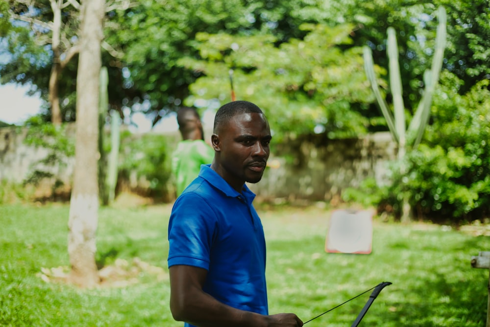 a man in a blue shirt holding a black object