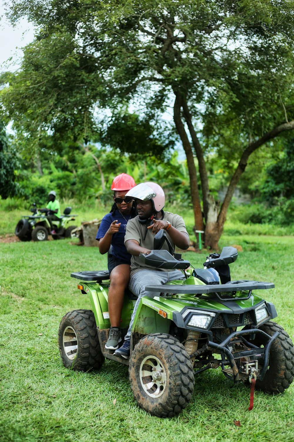 a man and a woman riding on the back of an atv