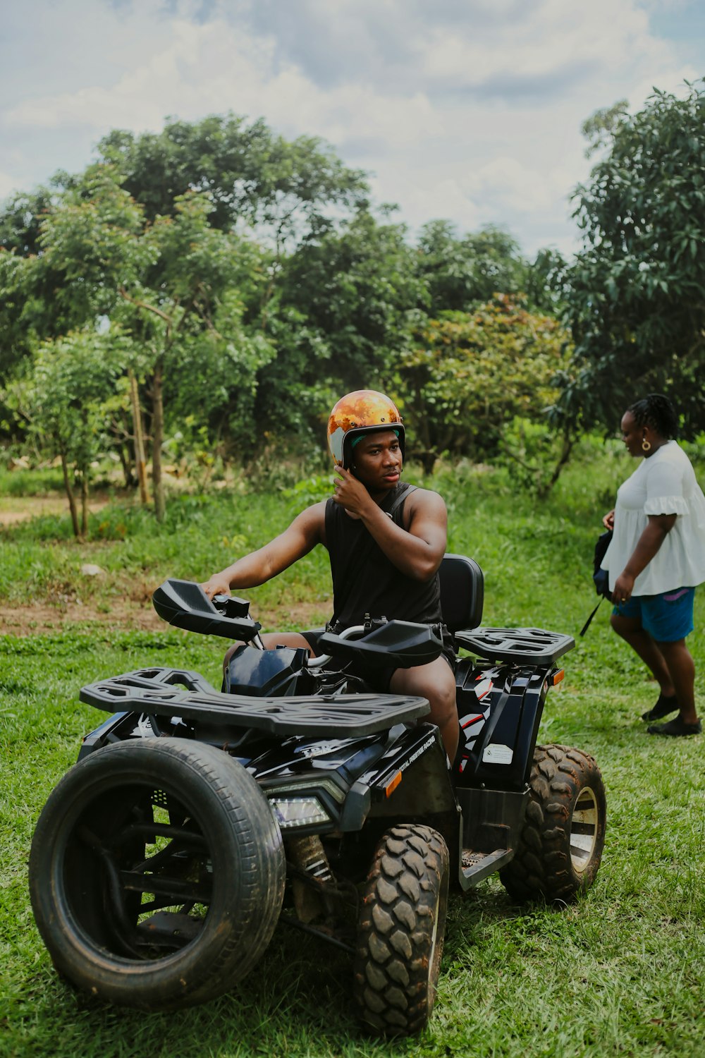 a man riding an atv on a lush green field