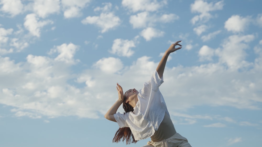 a woman reaching up to catch a frisbee