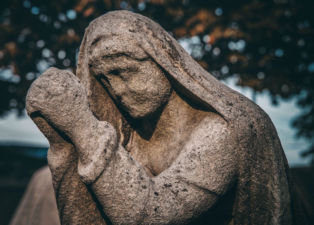 a statue of a person holding their head in their hands