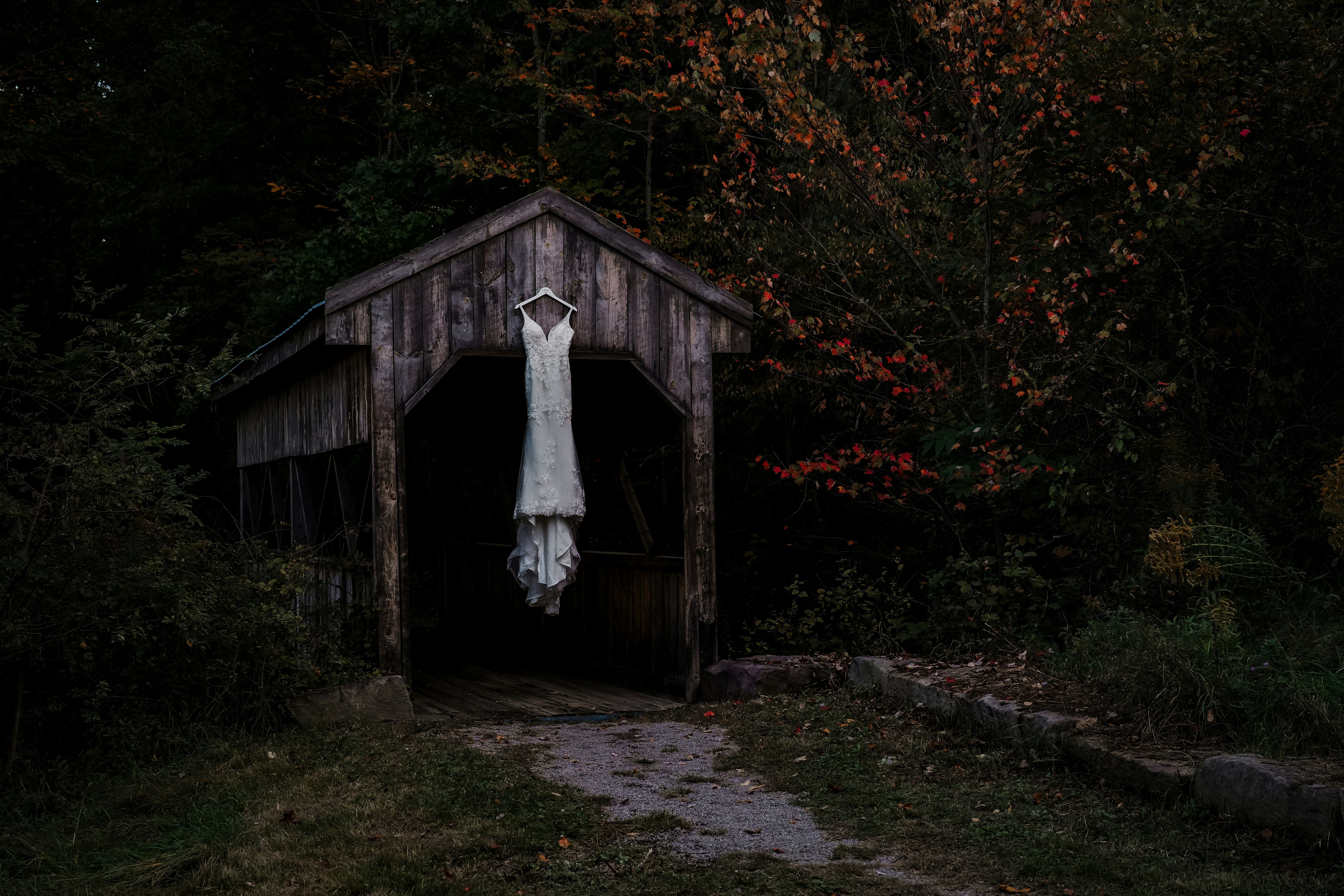 a white wedding dress hanging from a wooden structure