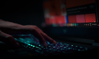 A user’s fingers lightly resting on a keyboard with visible soft copper accents.