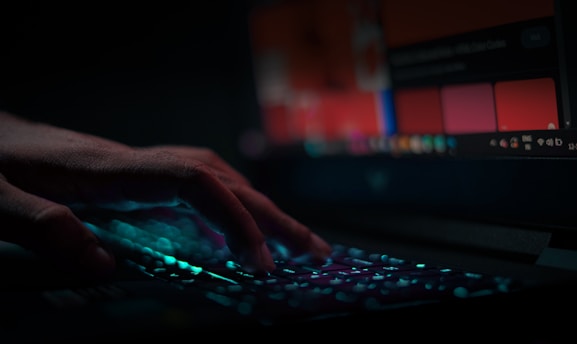 A user’s fingers lightly resting on a keyboard with visible soft copper accents.