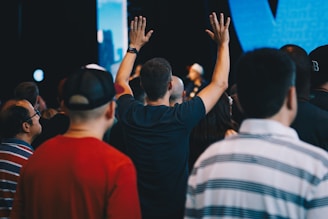 Hands raised in worship during a live radio broadcast event on the island.