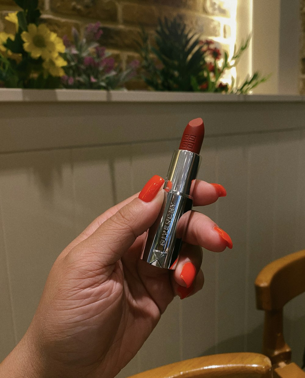 a woman holding a lipstick in her hand