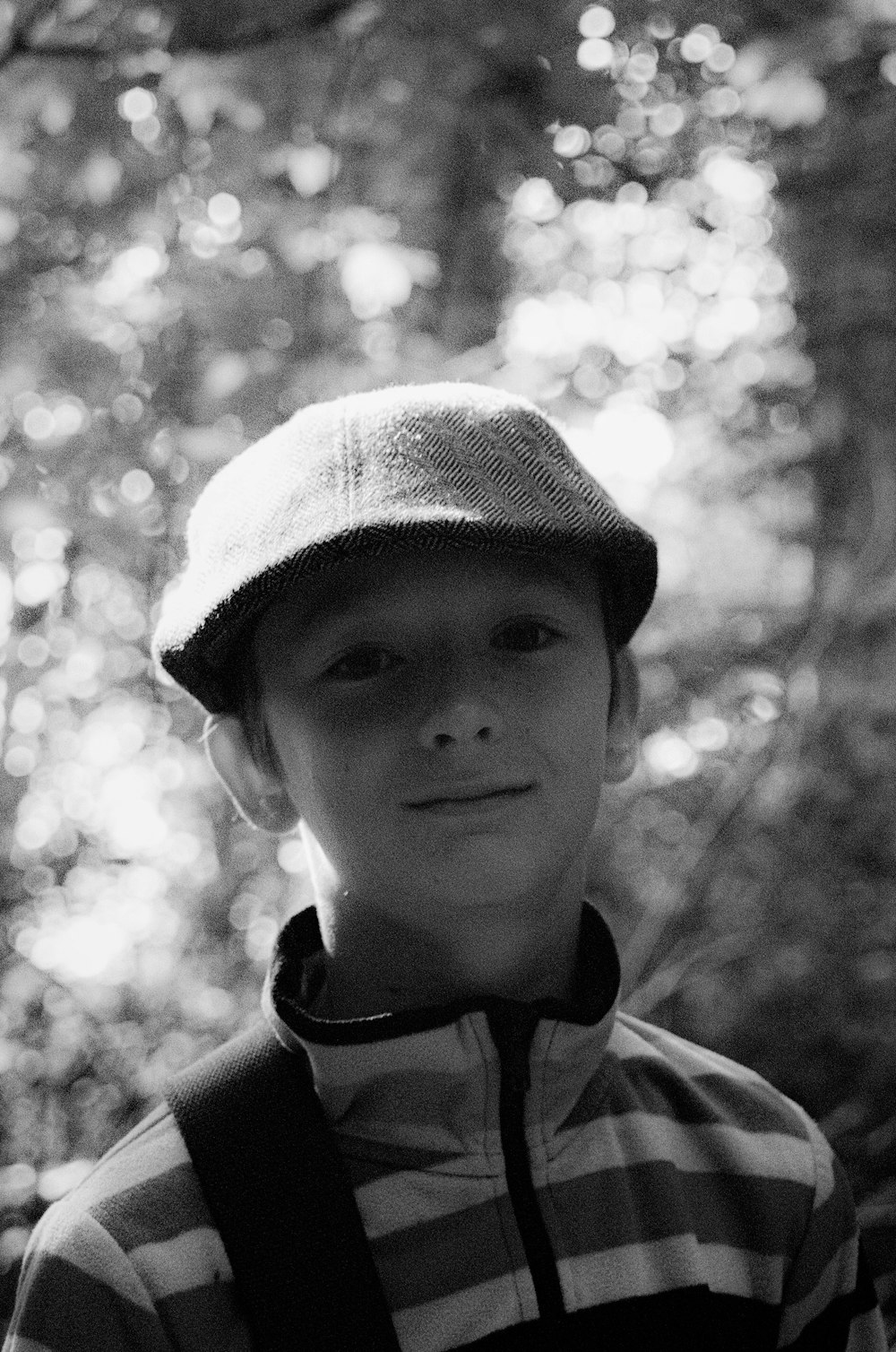 a black and white photo of a boy wearing a hat