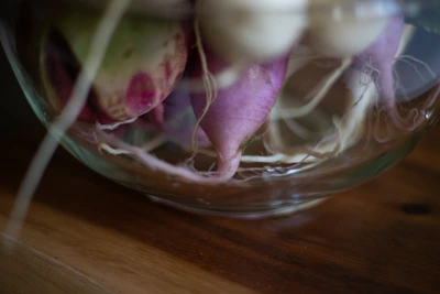 Close-up of fresh burdock root and iodine crystals on a natural wooden surface.