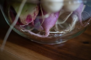 Close-up of fresh Gorran Toula roots displayed on a rustic wooden table.
