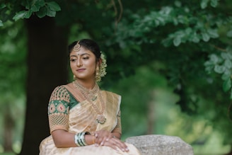 a woman in a sari sitting on a rock