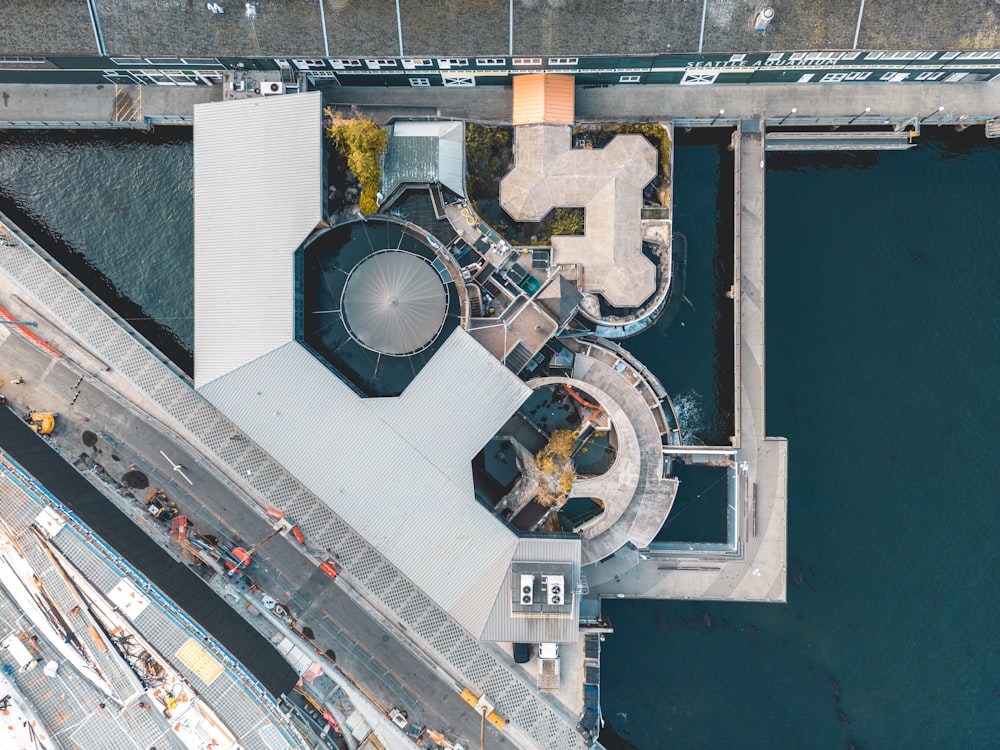 an aerial view of a building next to a body of water