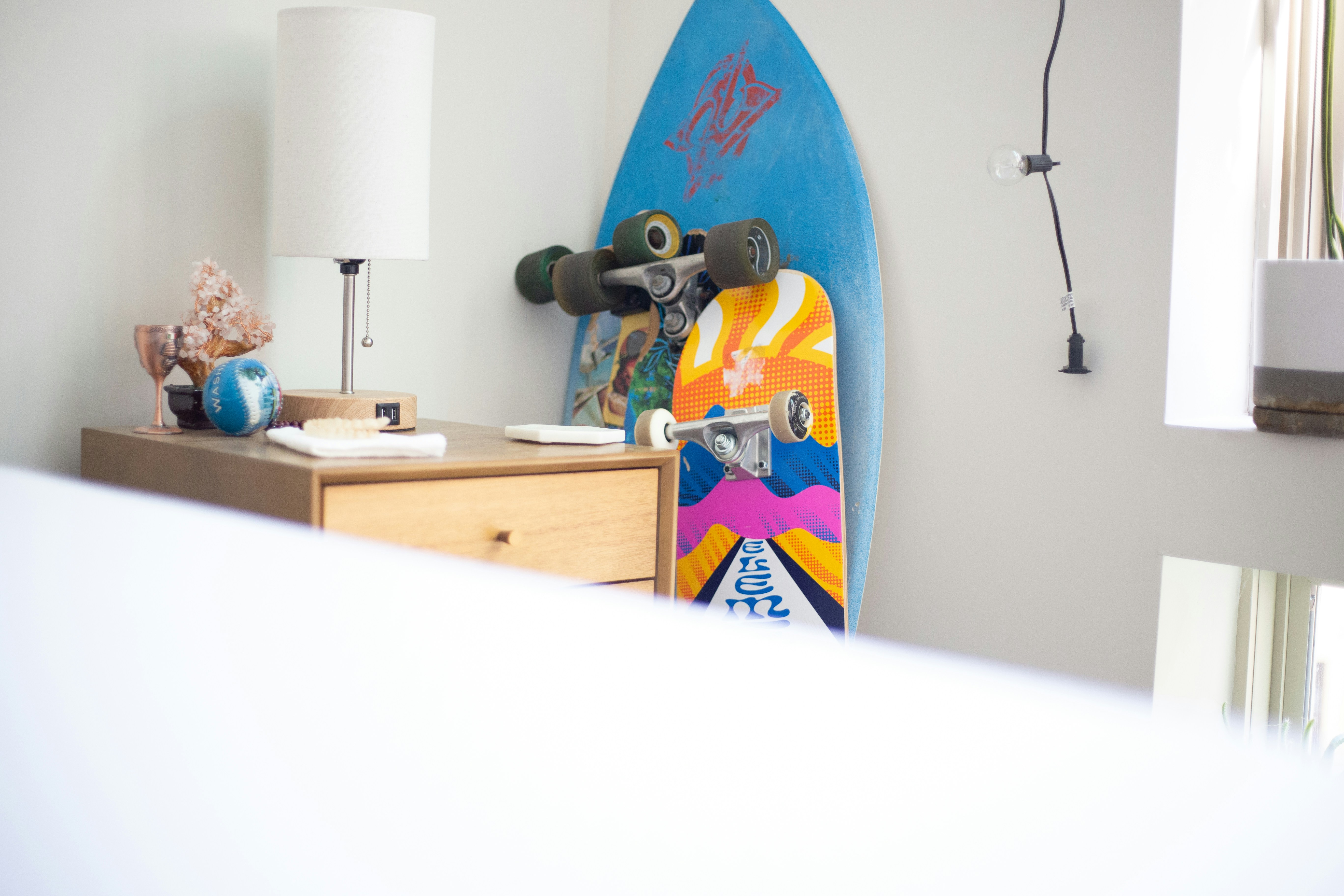 a skateboard leaning up against a wall next to a lamp