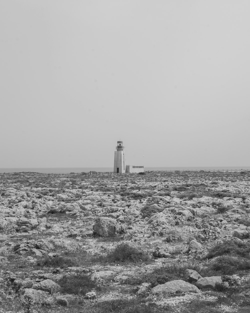 a black and white photo of a lighthouse in the distance