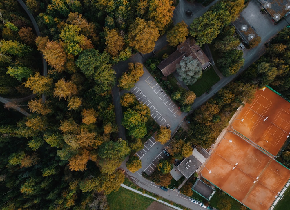 an aerial view of a tennis court surrounded by trees