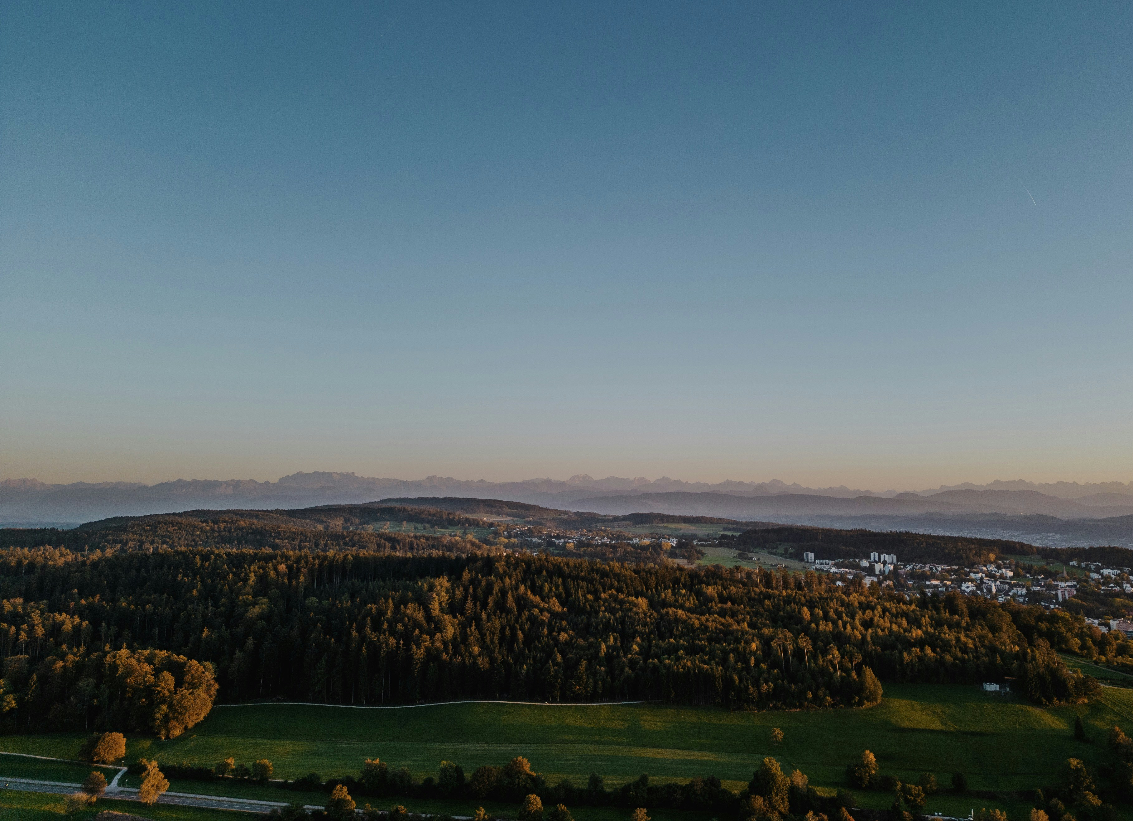 Panoramic mountain landscape view at golden hour with rolling forested hills