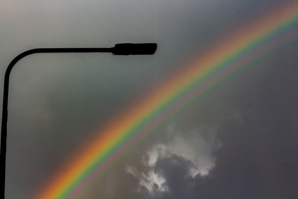 a street light with a rainbow in the sky