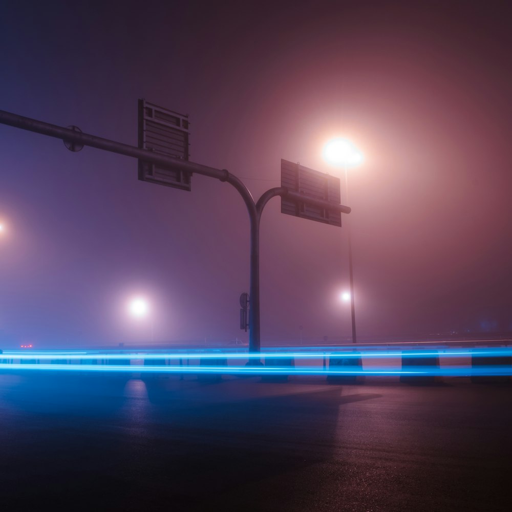 a foggy night with street lights and street signs