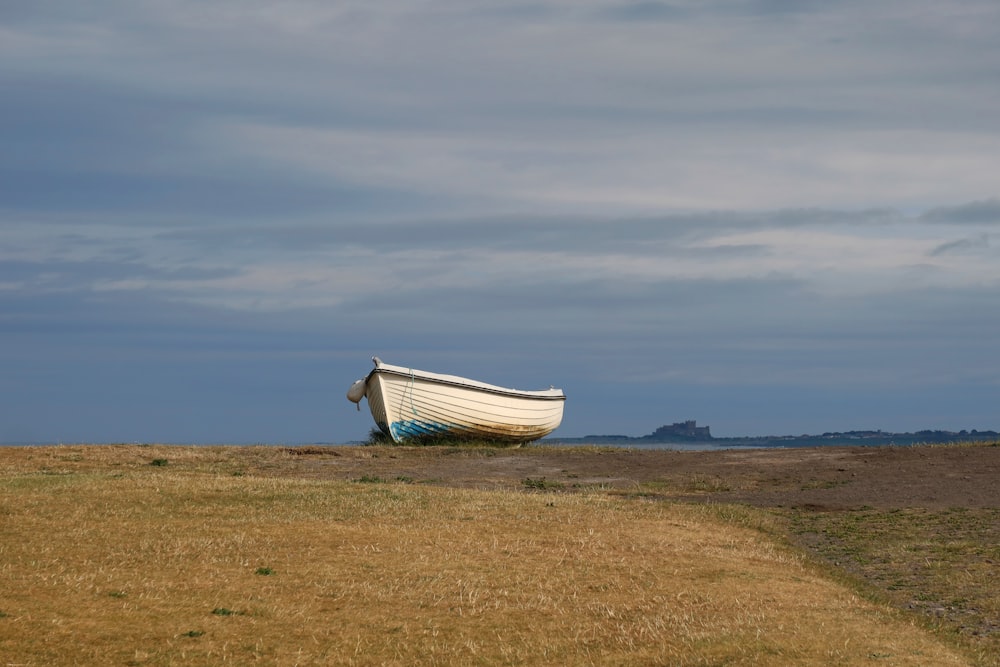 a boat sitting on top of a dry grass field