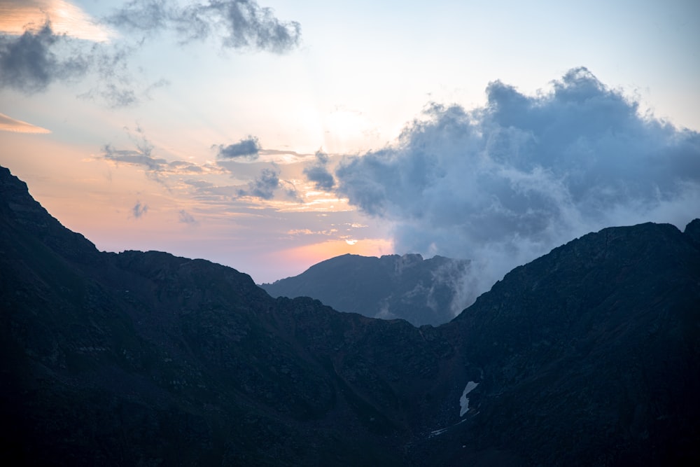 the sun is setting over a mountain range