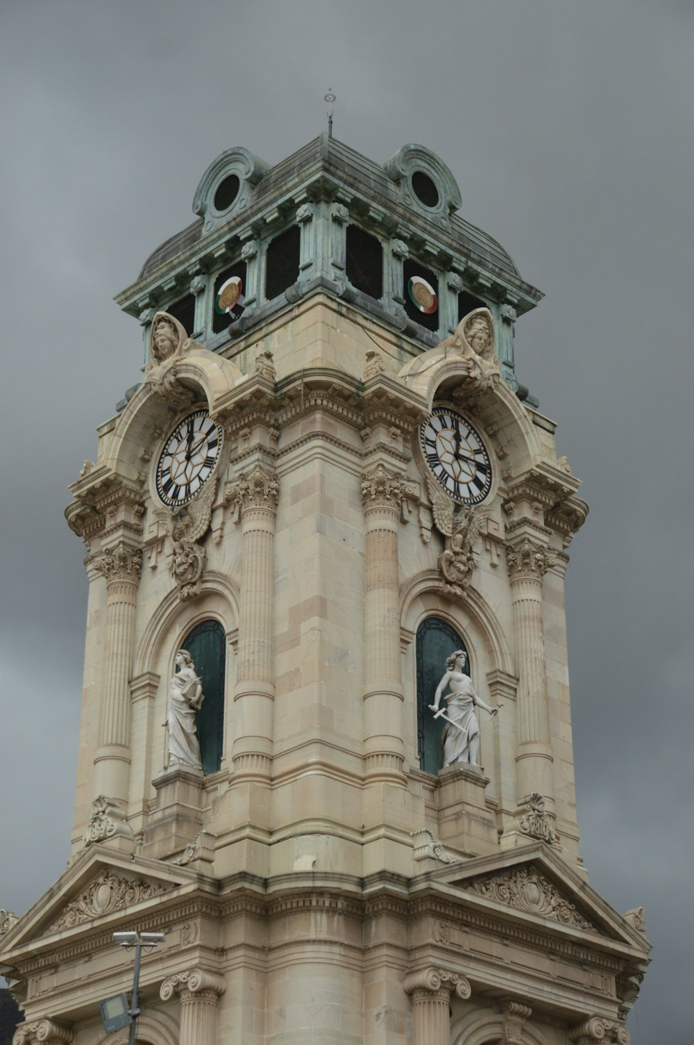ein hoher Glockenturm mit einer Uhr an jeder Seite