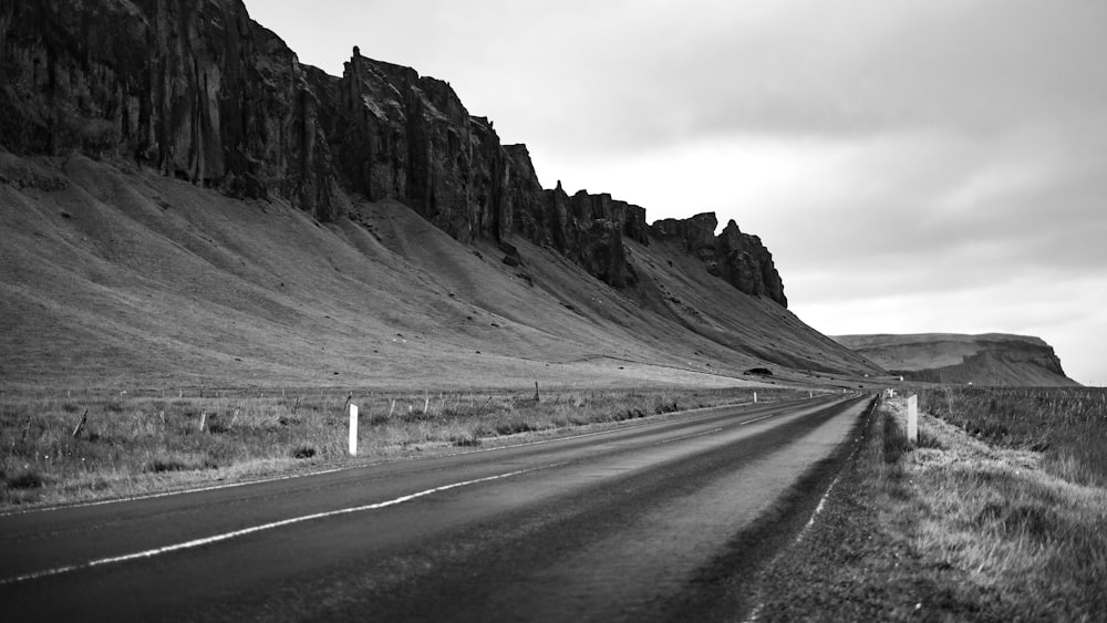 a black and white photo of a mountain road