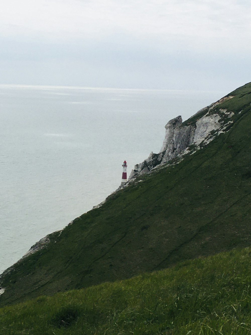 a grassy hill with a lighthouse on top of it