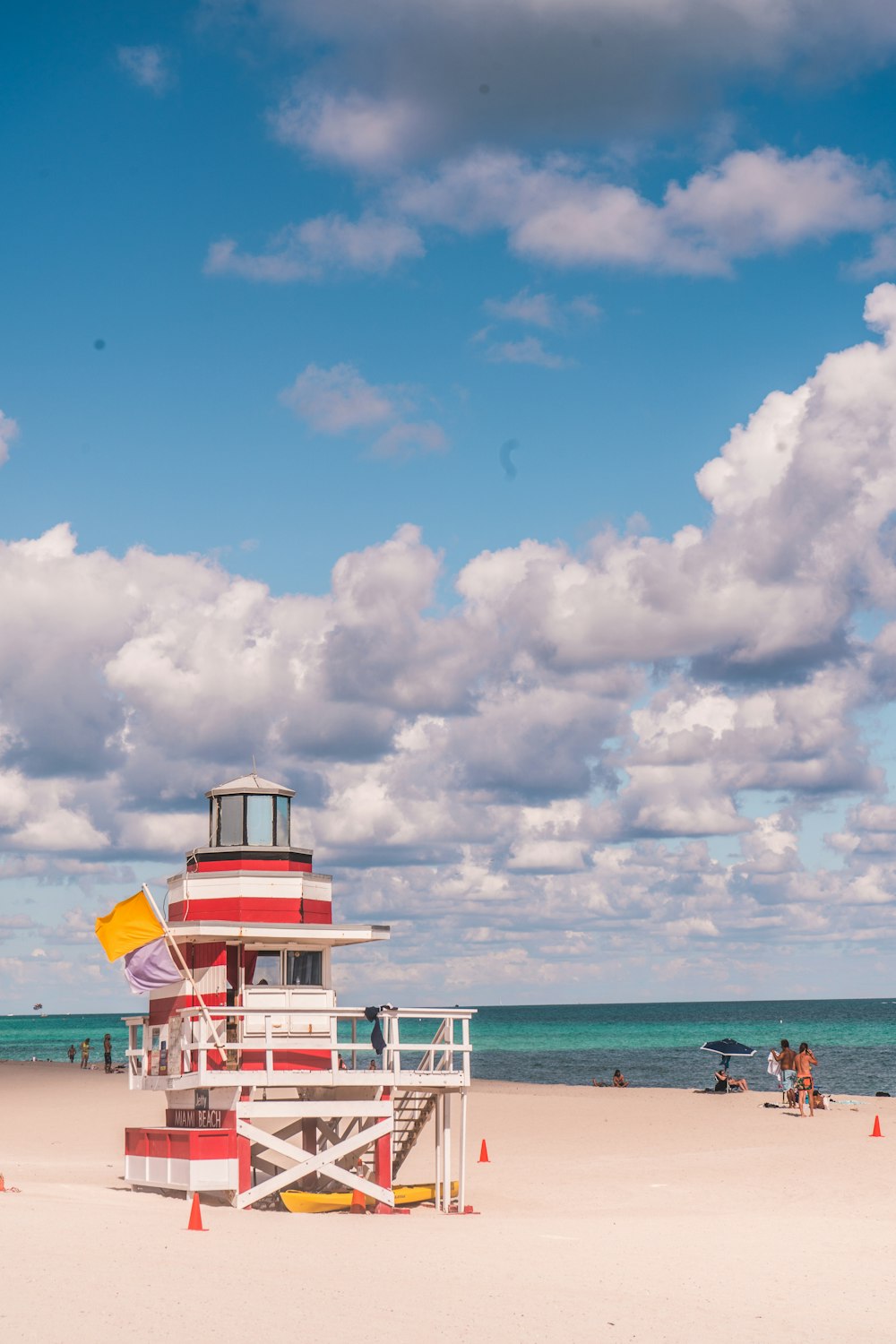 a lifeguard tower on a beach with people in the background