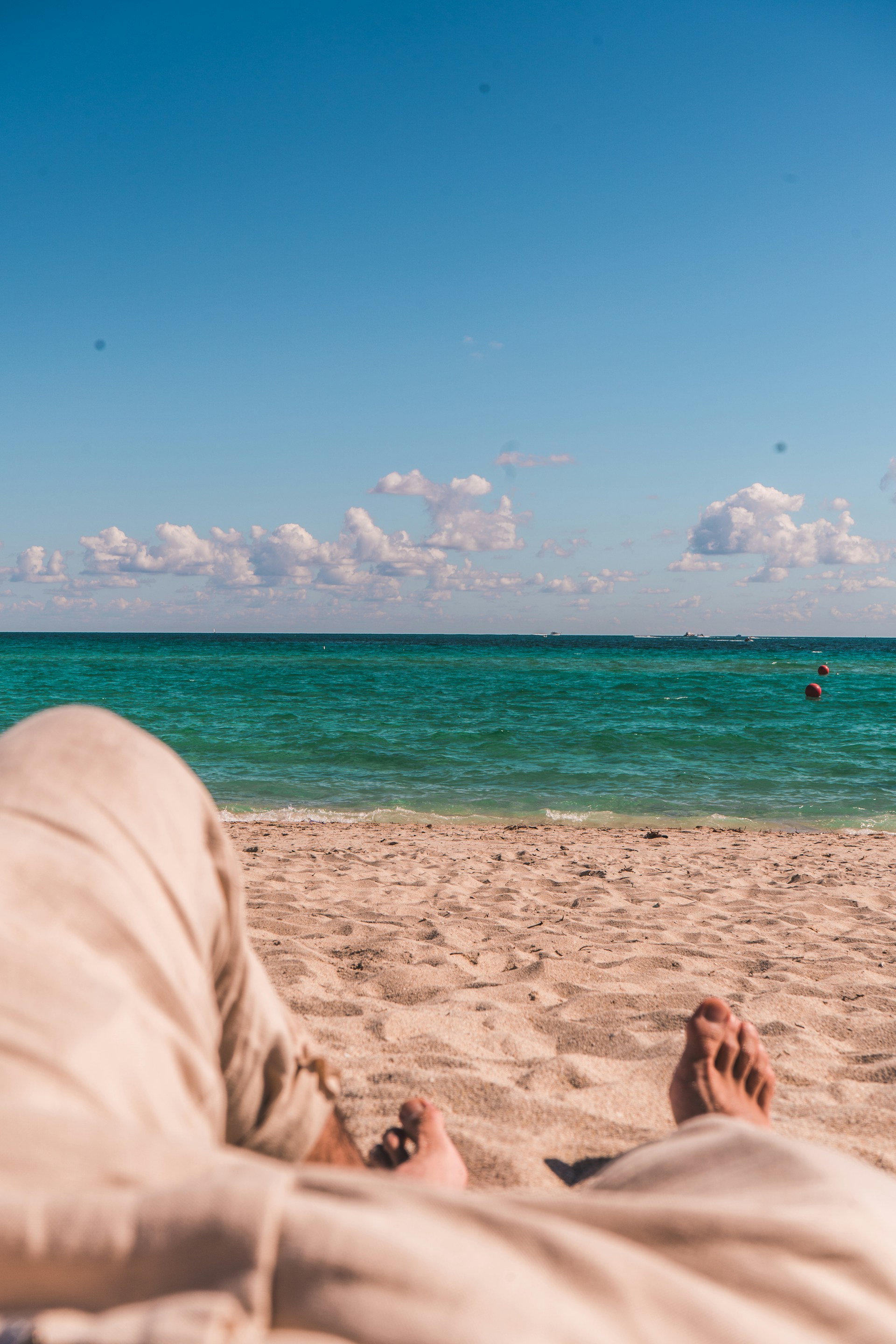 A serene beach scene with feet in the sand, conveying relaxation and wellness.