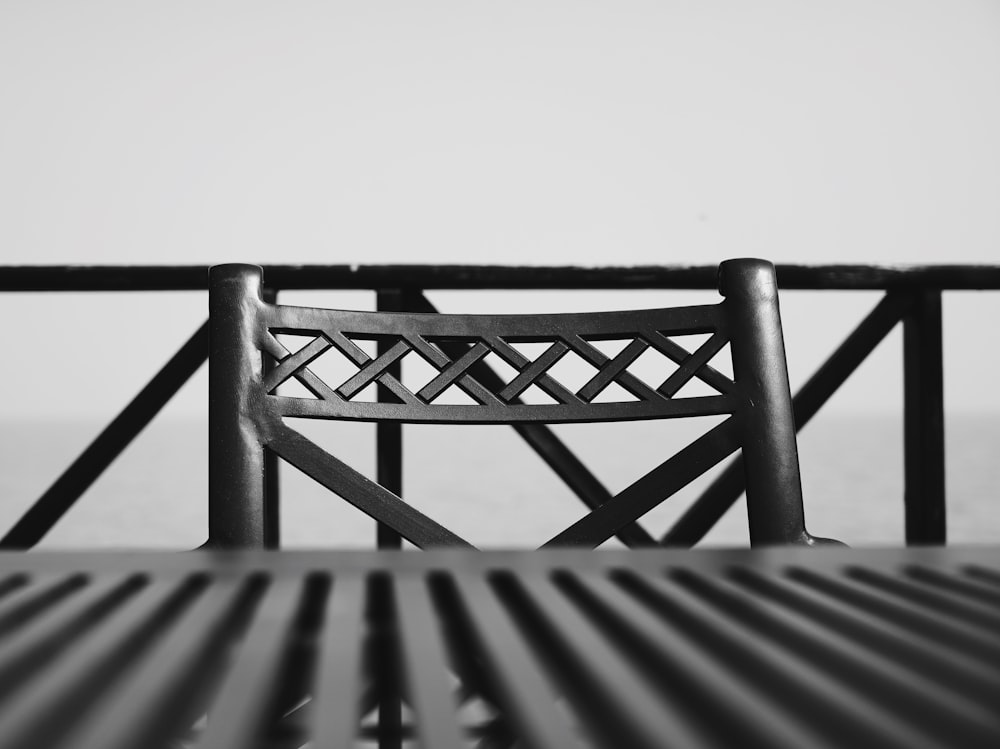 a black and white photo of a metal bench