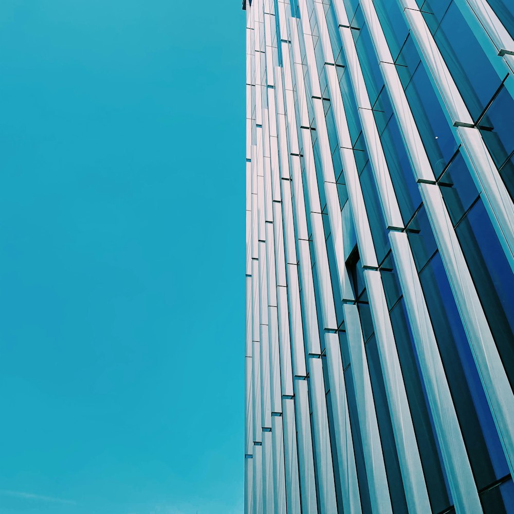 a tall glass building with a blue sky in the background