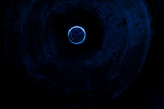 a blue light in the middle of a dark tunnel