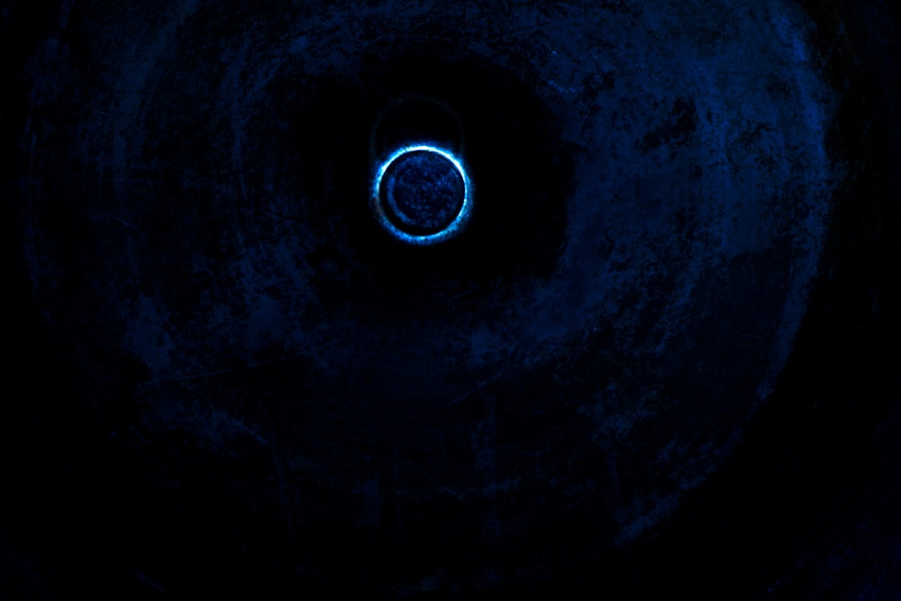 a blue light in the middle of a dark tunnel