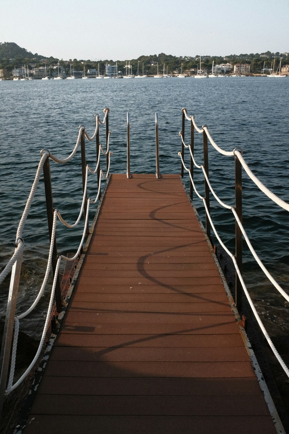 a wooden dock with metal railings leading into the water