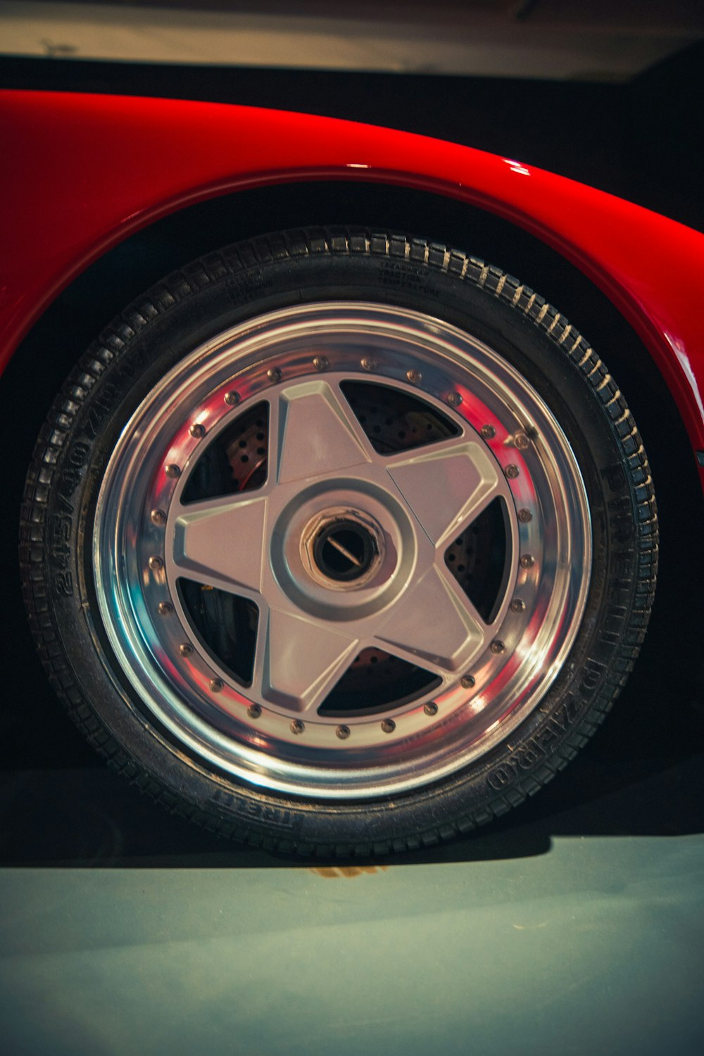 a close up of a red sports car wheel