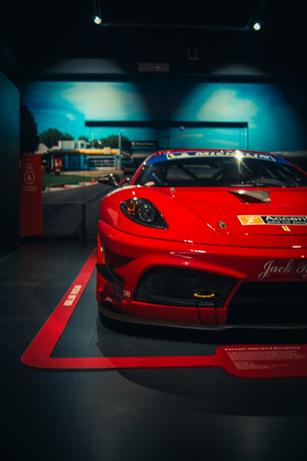 a red sports car on display in a dark room