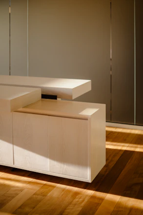 A sleek, modern custom wood cabinet with warm lighting highlighting the fine craftsmanship.