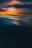 A serene abstract landscape featuring a dramatic blend of colors, with deep blues transitioning into warm hues of orange and soft pinks. The image creates an impression of a sunset or sunrise reflected on a smooth water surface, with soft blending and gentle waves creating a calming visual effect.