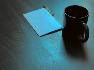 A confidential folder stamped 'Urgent' lying next to a cup of coffee on a dark wooden table.