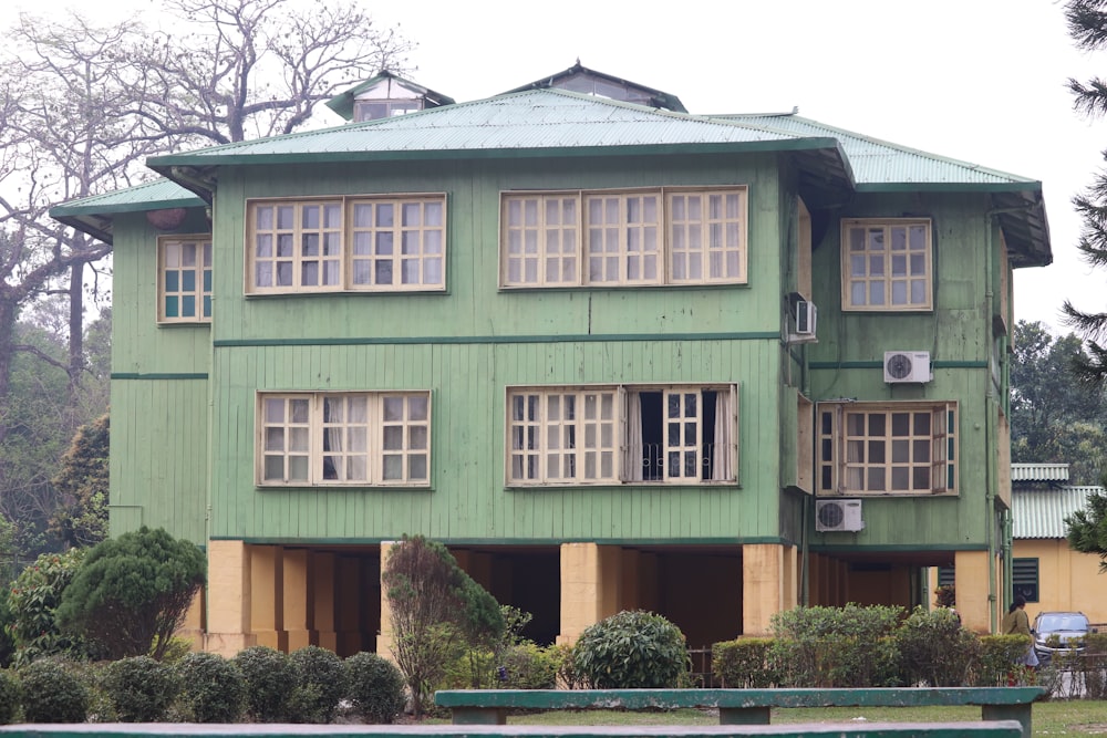 a large green building with lots of windows