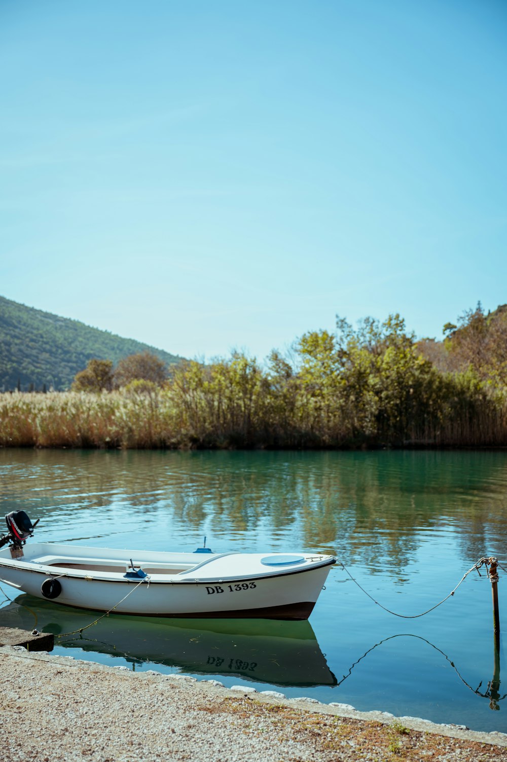 a small white boat floating on top of a lake