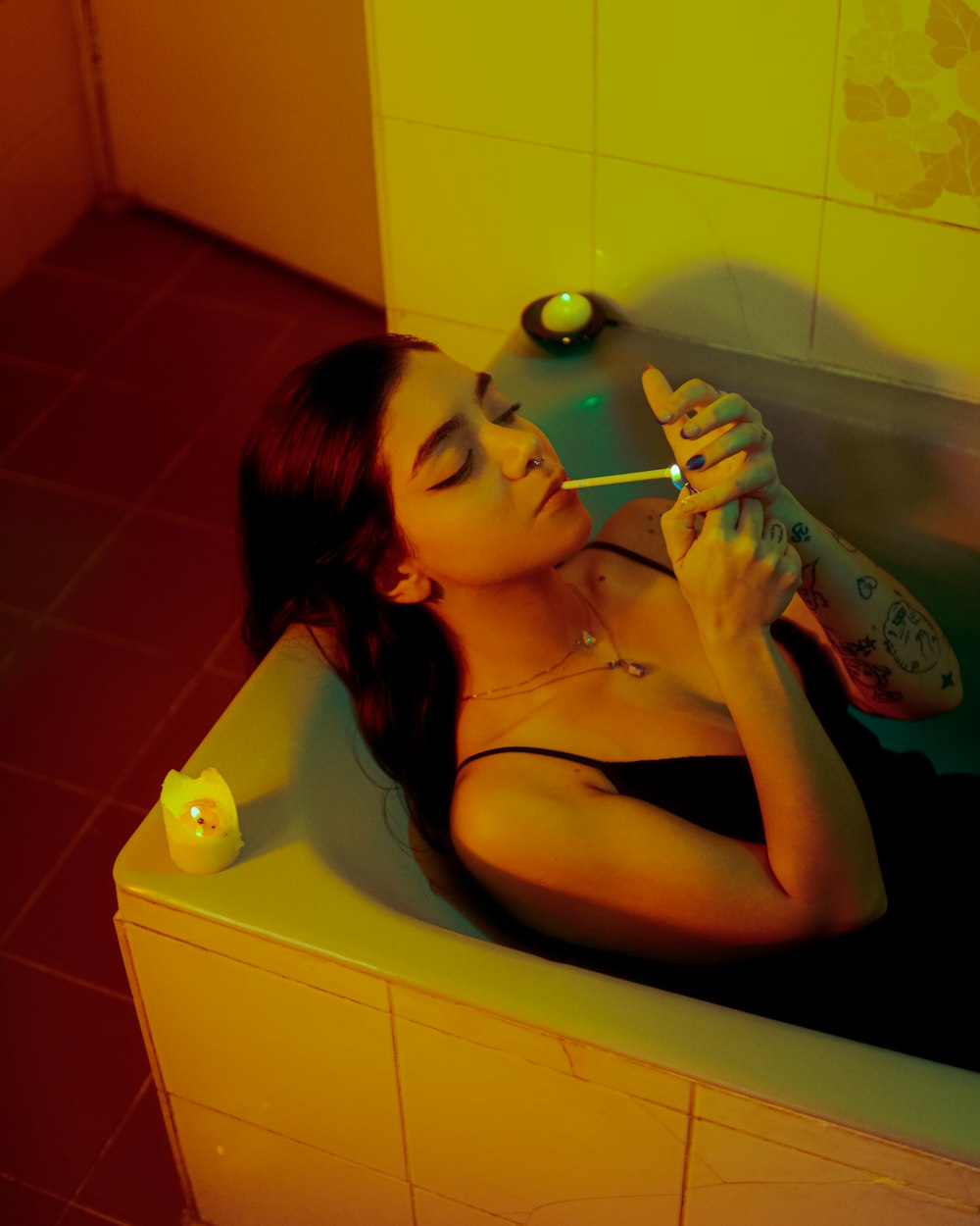 a woman laying in a bathtub with a toothbrush in her mouth