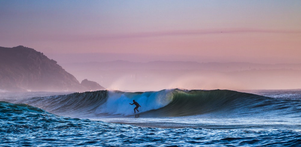 a man riding a wave on top of a surfboard