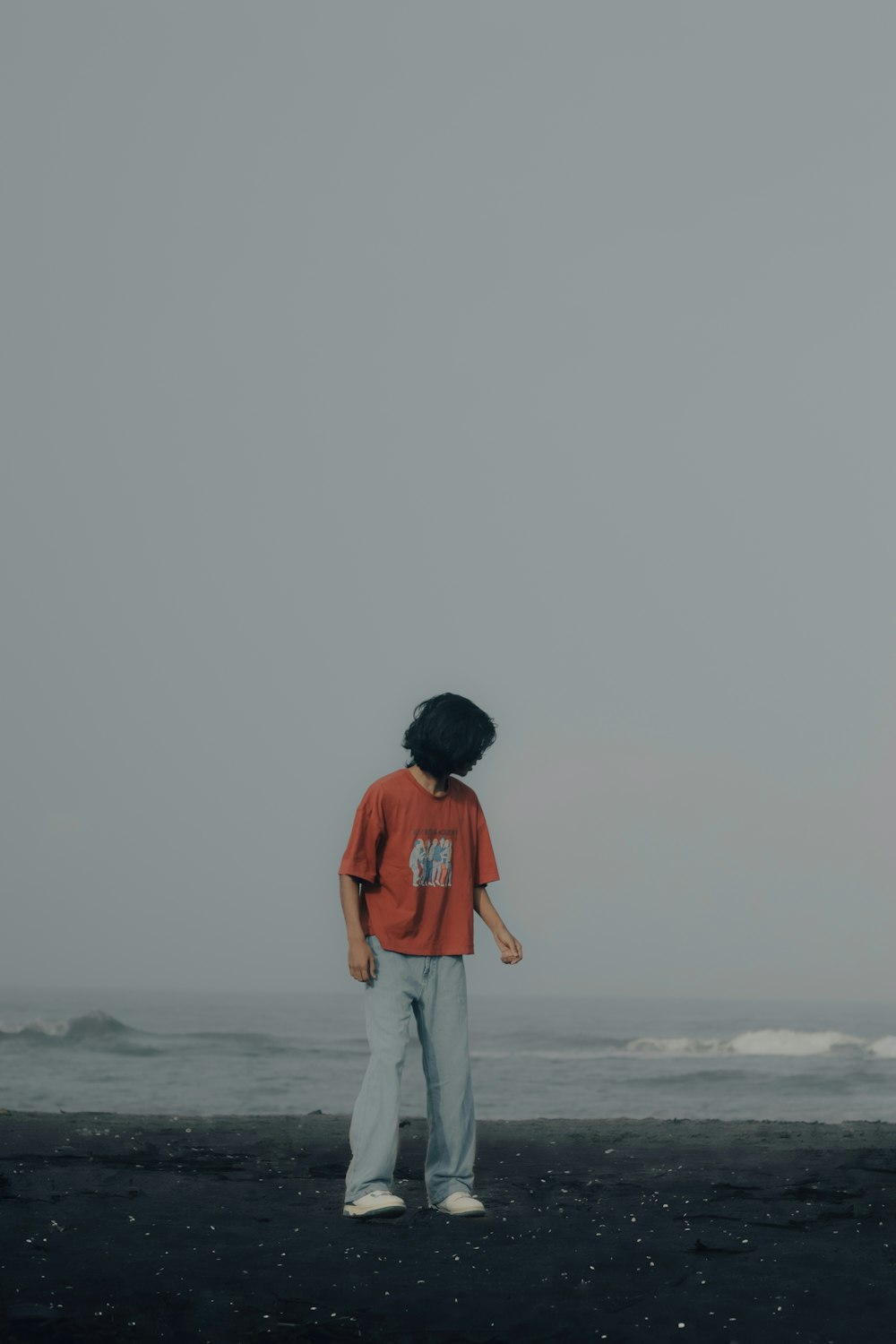 a person standing on a beach near the ocean