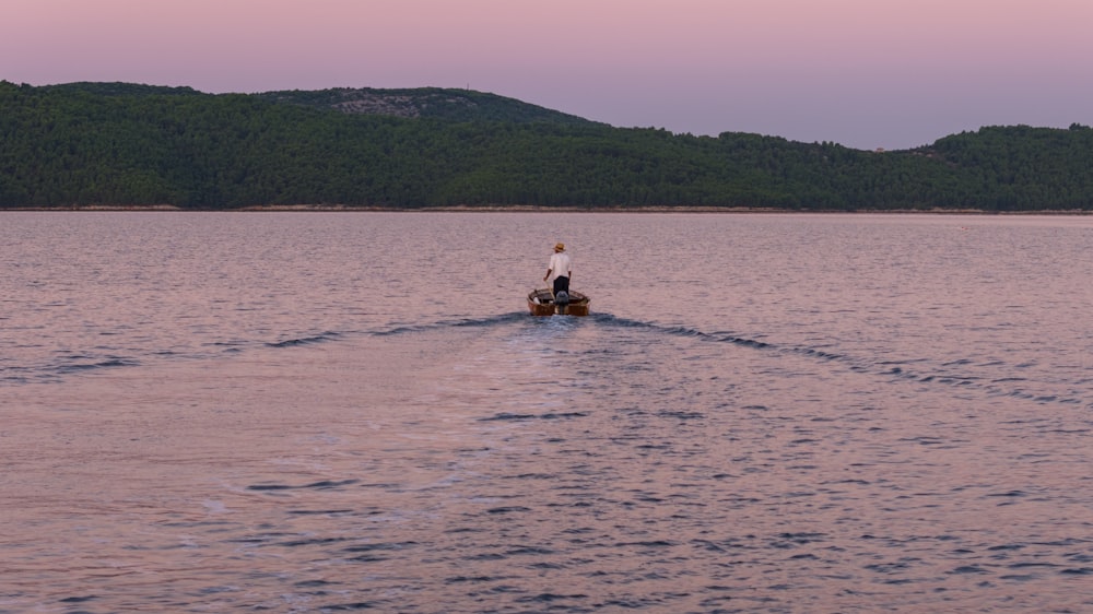 uma pessoa andando de barco no meio de um lago