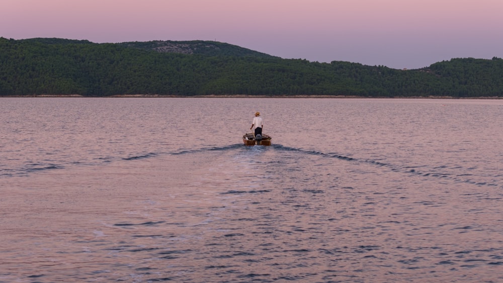 una persona che cavalca una barca nel mezzo di un lago