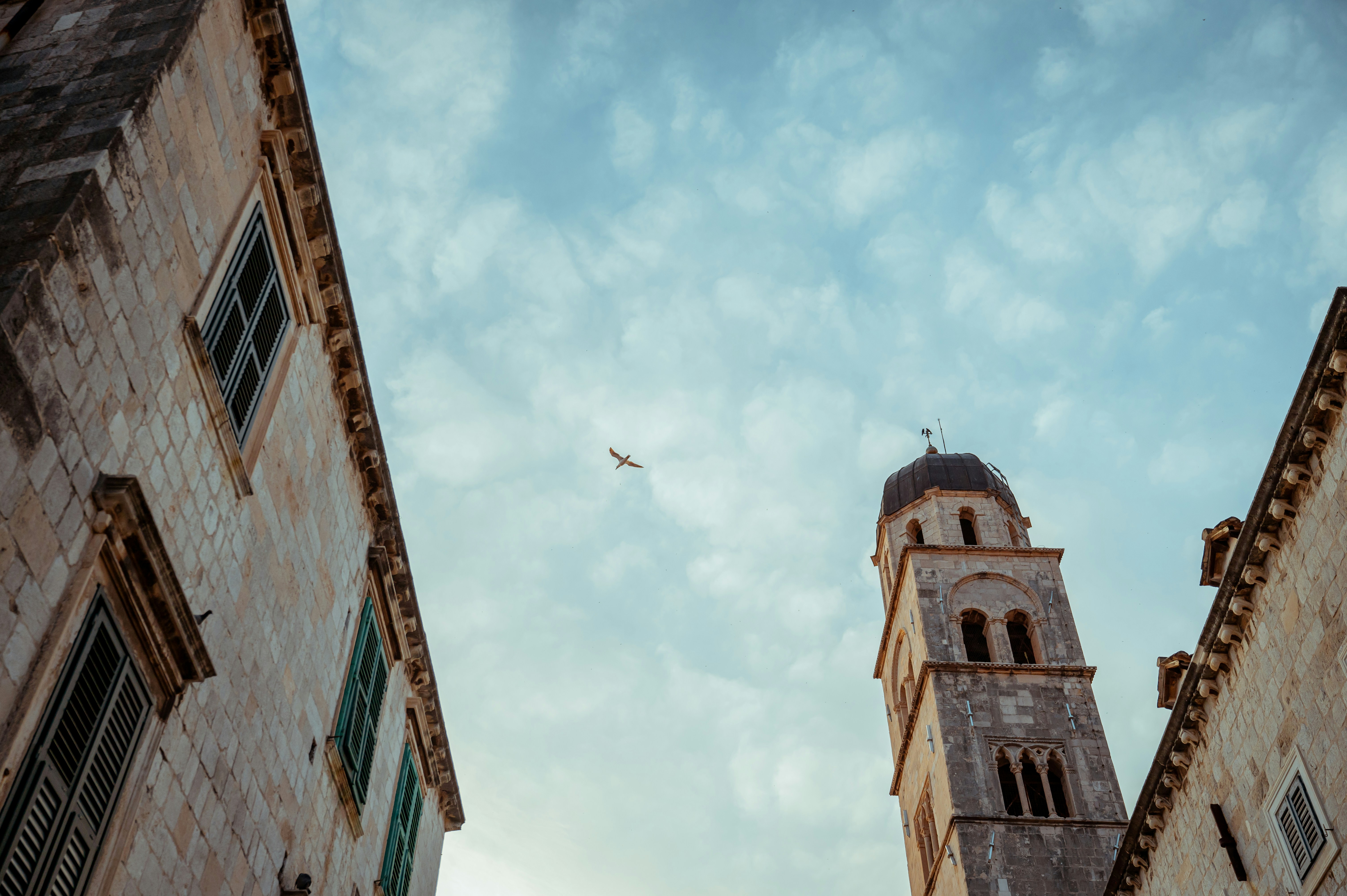 an airplane flying over a building with a steeple, 