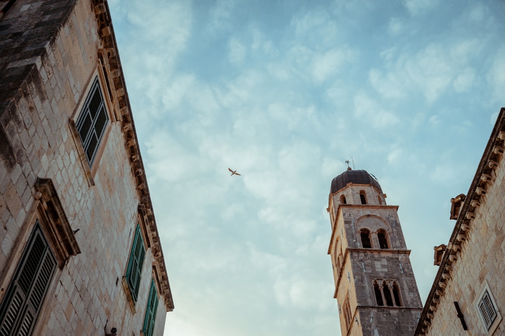 an airplane flying over a building with a steeple