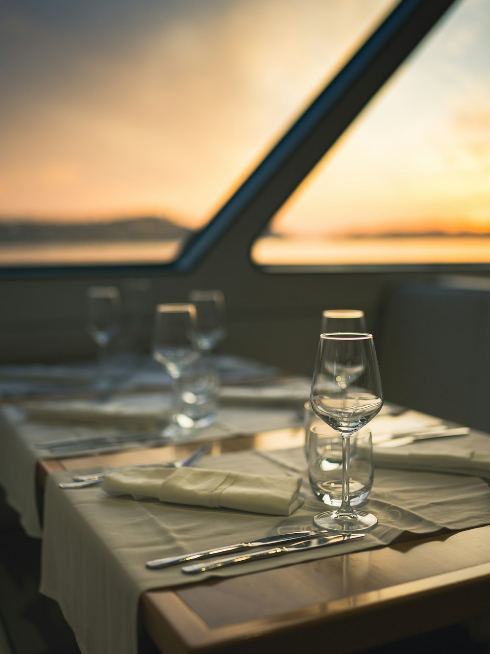 a table with place settings and wine glasses on it